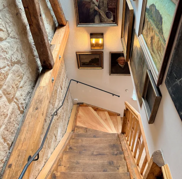 Treppenhaus mit Sandsteinwand und Holzstufen