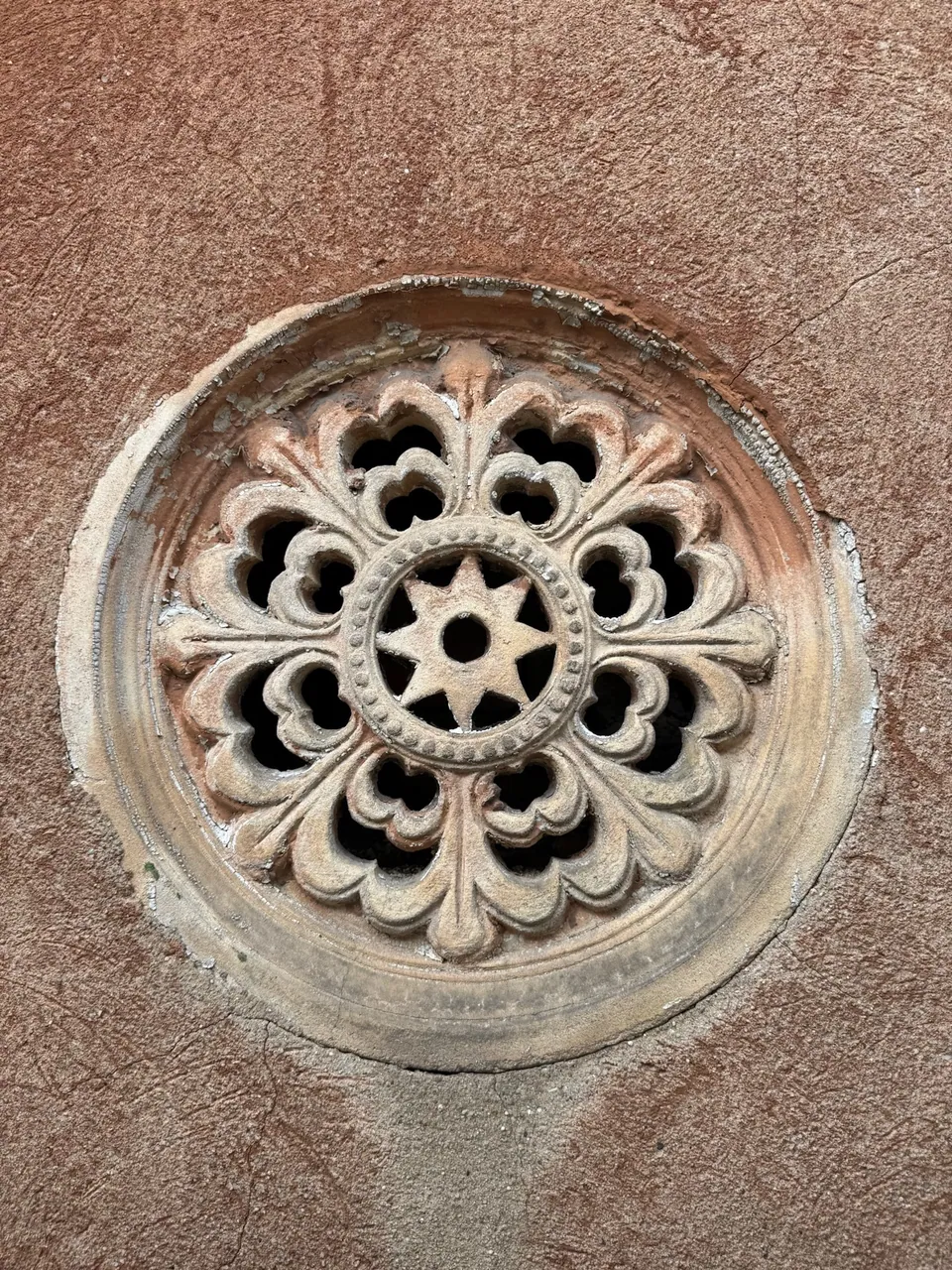 Das Spiraculum: eine runde, durchbrochene Sandsteinrosette in der Fassade