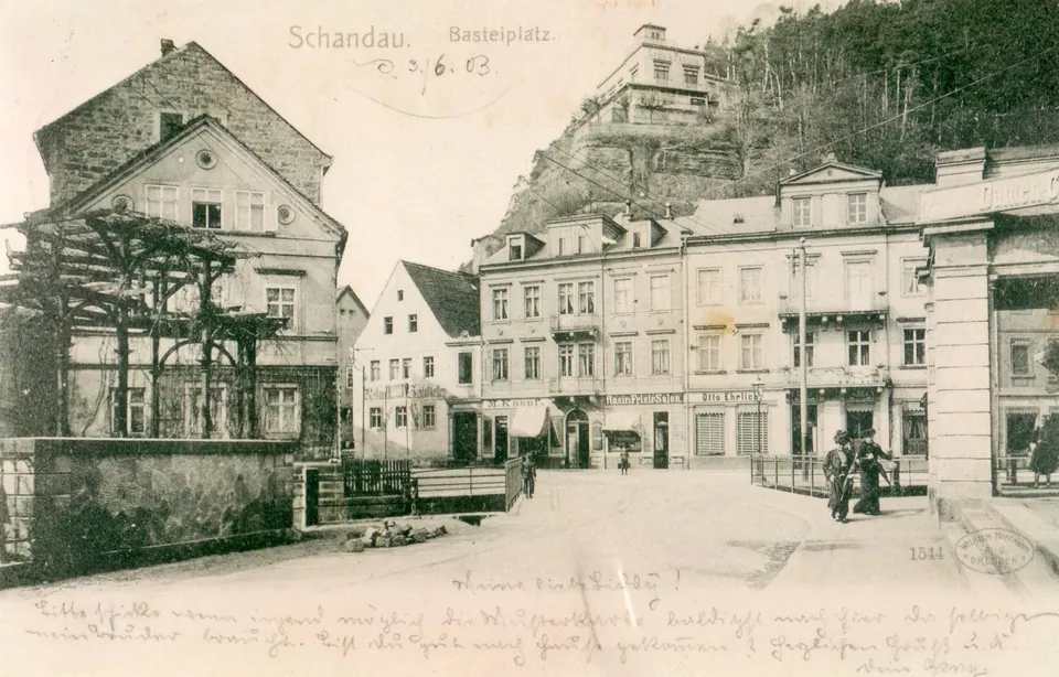 Postkarte von 1903: der Basteiplatz in Schandau, links das Haus, davor der Bach